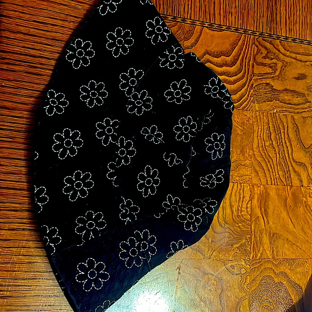 A black bucket hat with white flowers all over.